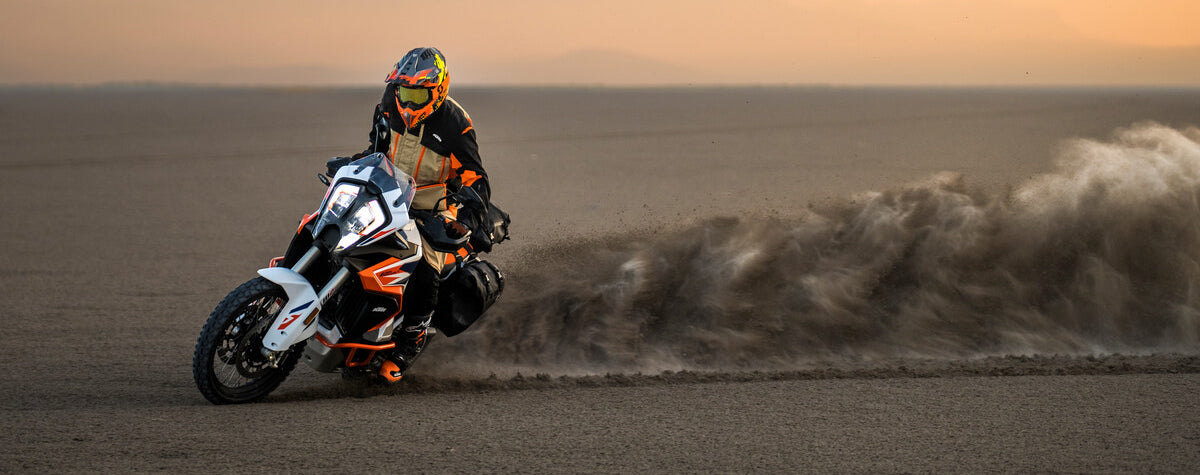 KTM motorcycle drifting through black sand
