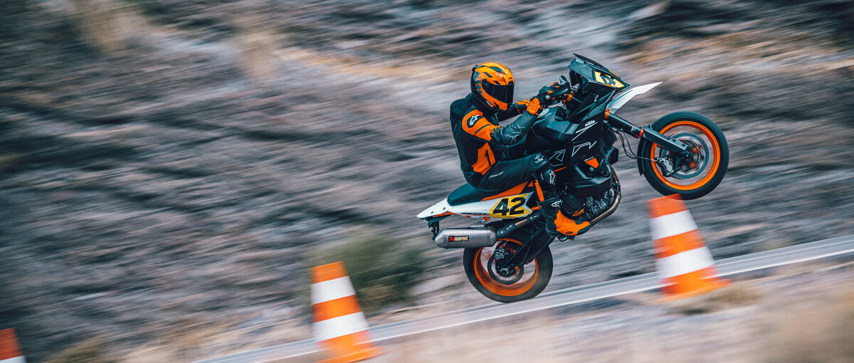 KTM Enduro motorcycle wheelie up country road